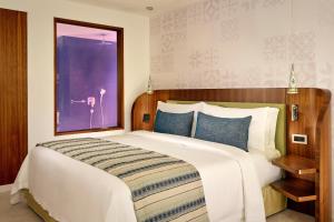 a bedroom with a large white bed with blue pillows at Parklane, a Luxury Collection Resort & Spa, Limassol in Limassol