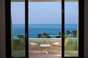 a room with a view of the ocean from a balcony at Parklane, a Luxury Collection Resort & Spa, Limassol in Limassol