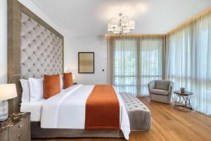 a bedroom with a large bed and a chair at Parklane, a Luxury Collection Resort & Spa, Limassol in Limassol