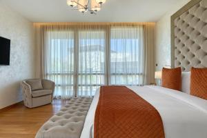 a bedroom with a large bed with a large window at Parklane, a Luxury Collection Resort & Spa, Limassol in Limassol