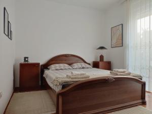 1 dormitorio con 1 cama grande con marco de madera en Apartment MILA city center-free parking en Vranje