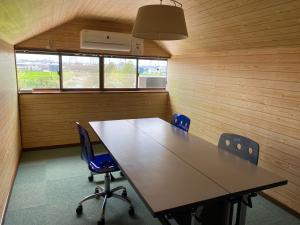 una sala de conferencias con una mesa larga y sillas en 快適に滞在&家族利用等におすすめ 洋室と和室が繋がったお部屋, en Gifu