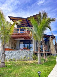 una casa con palmeras delante en DIEM Vichayito Beachfront Eco-Luxury, en Vichayito