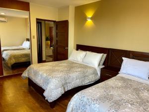 a hotel room with two beds and a mirror at Apartamento céntrico de lujo StaCruz. in Santa Cruz de la Sierra
