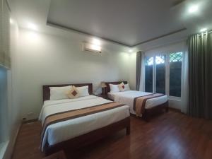 pokój hotelowy z 2 łóżkami i oknem w obiekcie GREENSPACE RESORT PHUQUOC w Duong Dong