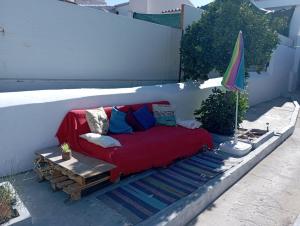 - un canapé installé sur une terrasse avec un parasol dans l'établissement O Refúgio do Pastor, à Sousel