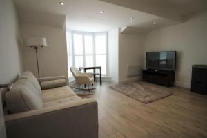 a living room with a couch and a television at 1 bedroom beachfront apartment in Monkwearmouth