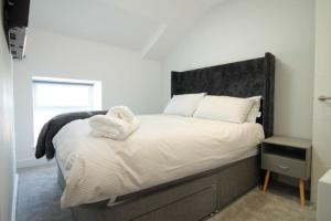 łóżko z białym wypchanym zwierzakiem na górze w obiekcie 1 bedroom beachfront apartment w mieście Monkwearmouth