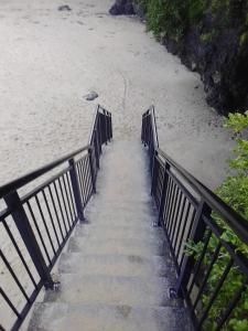 uma escada que leva até uma praia com areia e água em Kiama Beach House & Private Beach & Newly Renovated em Kiama