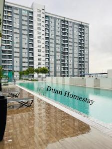龍溪村的住宿－Duan Homestay @ Cybersouth (Muslim shj)，一座大建筑前的游泳池
