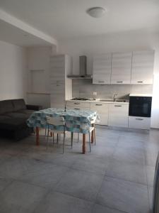 a living room with a table and a kitchen at Appartamento Civico Trentuno in Porto SantʼElpidio