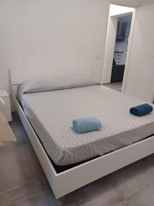 a white bed with a blue pillow on it at Appartamento Civico Trentuno in Porto SantʼElpidio