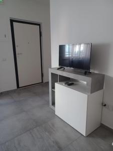 una sala de estar con TV en un armario y una puerta en Appartamento Civico Trentuno en Porto SantʼElpidio