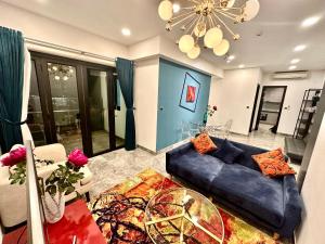 een woonkamer met een blauwe bank en een tafel bij Luxury Gold Apartment 86 : D1- Mension , Rooftop Pool - District 1 in Ho Chi Minh-stad