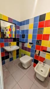 bagno colorato con servizi igienici e lavandino di Accomodation Libertino a Tropea