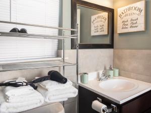 a bathroom with a sink and a mirror and towels at Stylish & family friendly 3 Bedroom - 8 mins to EWR in Elizabeth