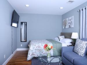 a living room with a bed and a blue couch at Stylish & family friendly 3 Bedroom - 8 mins to EWR in Elizabeth