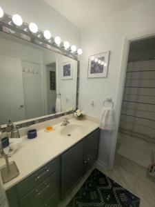 a bathroom with a sink and a large mirror at Adaora's Oasis private room in Millersville