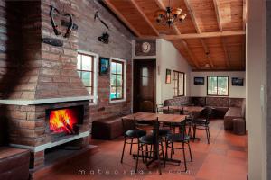 a restaurant with a fireplace and tables and chairs at Mateospaxi in Machachi
