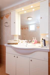 ein Badezimmer mit einem weißen Waschbecken und einem Spiegel in der Unterkunft Sunset Studio in Cherronisos