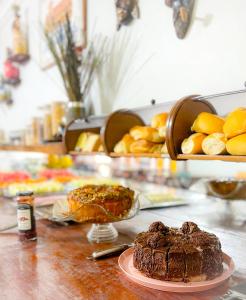 Pousada dos Caminhos في أراكاجو: طاولة مع كعكة شوكولاته وصحن خبز