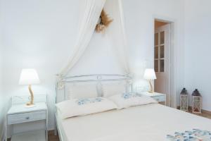 1 dormitorio blanco con 1 cama blanca y 2 mesitas de noche en Sunset Studio en Cherronisos