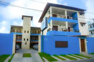 une maison bleue et blanche avec un parking dans l'établissement Pousada dos Caminhos, à Aracaju