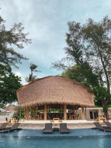 una grande capanna con sedie e una piscina di Gili Air Lagoon Resort By Waringin Hospitality a Gili Air