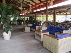 een patio met blauwe banken, tafels en planten bij Saracen Bay Resort in Koh Rong Sanloem