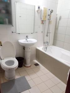 a bathroom with a toilet and a sink and a bath tub at Minesview condo in Baguio