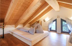 a bedroom with a bed in a room with wooden ceilings at Schoorenmoos Lodge in Dietmannsried