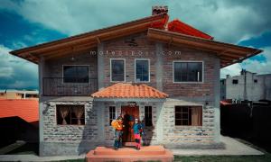 two people standing in front of a house at Mateospaxi in Machachi