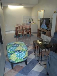 - un salon avec une chaise et une télévision dans l'établissement Adinda Syariah B 09 Paseban ke 3, 