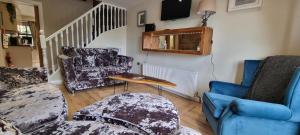 sala de estar con 2 sillas y mesa en Frontview Cottage - Sleeps 6 en Ballynahinch