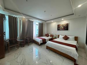 Happy Hotel في Uông Bí: غرفة فندقية بسريرين وطاولة