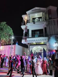 un grupo de personas bailando frente a un edificio en Hill Top Residency, en Sawāi Mādhopur