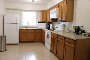 uma cozinha com armários de madeira e electrodomésticos brancos em Hidden Emerald-Apartment with Kitchen and Laundry em Lakeland