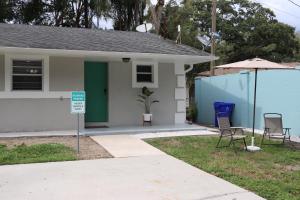 a house with a blue door and two chairs and an umbrella at Hidden Emerald-Apartment with Kitchen and Laundry in Lakeland