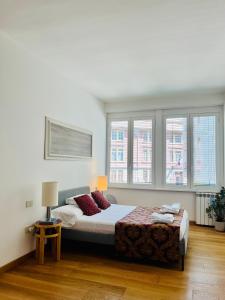 a bedroom with a large bed and two windows at Brera Apartment in Milan