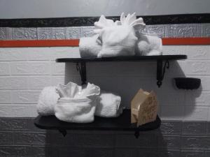 two shelves with towels and a box on a wall at Tashari-dae Inn king suite in Mandeville