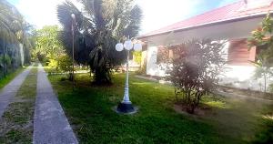 uma luz de rua na relva ao lado de uma casa em The Islander Hotel em Grand'Anse Praslin