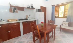 a kitchen with a wooden table and a table and chairs at The Islander Hotel in Grand'Anse Praslin