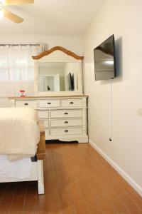 a bedroom with a bed and a dresser with a mirror at Hidden Ruby-Apartment with Kitchen and Laundry in Lakeland