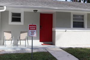 a red door on a house with a sign in front at Hidden Ruby-Apartment with Kitchen and Laundry in Lakeland