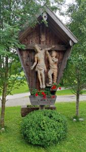 uma estátua de duas pessoas numa casa de pássaros em Kranzmuehle - Ankommen am Achensee em Achenkirch