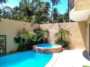 a swimming pool in a backyard with palm trees at Villa De Santos Acapulco Playa Bonfil Alberca in Acapulco