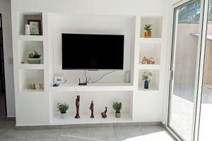 sala de estar con TV en una pared blanca en Villa De Santos Acapulco Playa Bonfil Alberca, en Acapulco