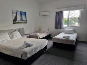a hotel room with two beds and a window at Seabreeze Beach Hotel in South West Rocks
