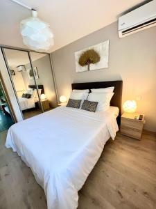 ein Schlafzimmer mit einem großen weißen Bett mit zwei Kissen in der Unterkunft Appartement Idéal in Petit-Bourg