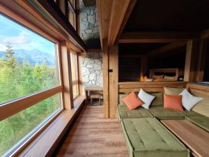 een kamer met een bank en grote ramen bij Apartman Mary Lou, Hotel Ovruc in Vysoké Tatry